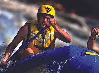 Student with WVU helmet whitewater rafting